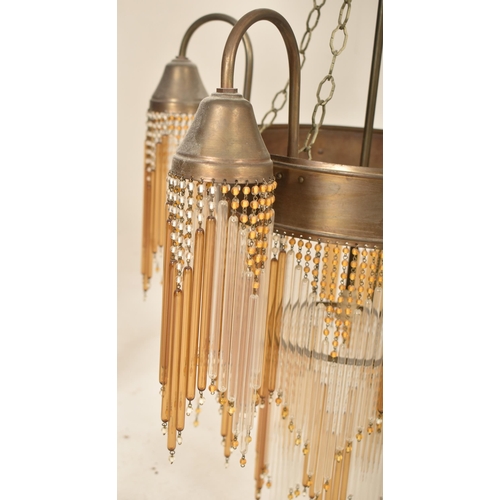 411 - An Art Deco inspired 20th century bronzed metal & glass rod four arm ceiling chandelier light. The c... 