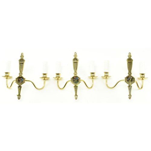 434 - A set of three Italian manner 20th century gilded metal twin arm wall sconces. Each light having a t... 