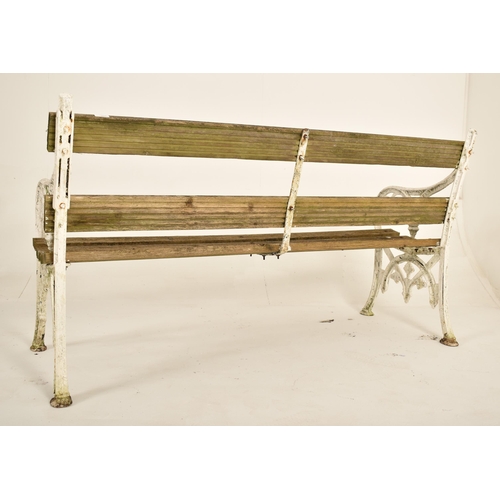 454 - A 19th century Victorian cast iron garden bench. The bench having cast iron sides with scrolled and ... 