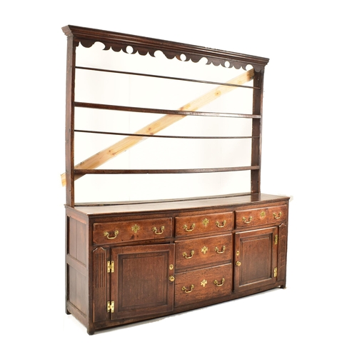 462 - A George III 18th century oak dresser. The dresser having an upright gallery plate rack with flared ... 