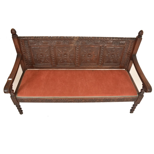 474 - A 19th century Victorian Gothic carved oak settle / bench. The settle having an intricately carved b... 