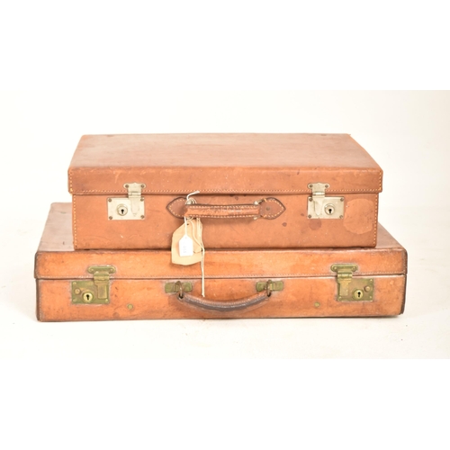 484 - A pair of vintage 20th century tan brown leather suitcases / travel case. Each case with metal / bra... 