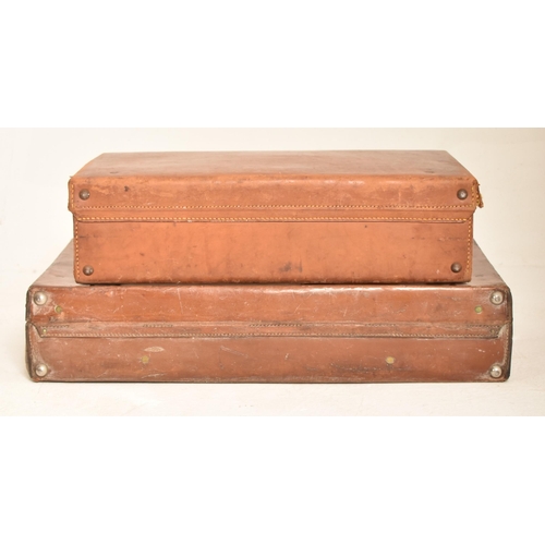 484 - A pair of vintage 20th century tan brown leather suitcases / travel case. Each case with metal / bra... 