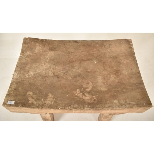 306 - A late 19th century / early 20th century beech butcher's block. The table having a squared concave t... 