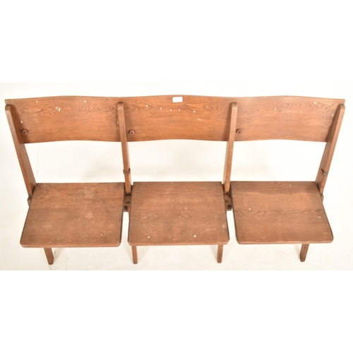 317 - An early 20th century 1920s oak & elm theatre three-seater bench. The bench having straight back res... 