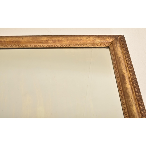 318 - A 19th century giltwood and gesso framed hanging mirror. The mirror of rectangular form having a cus... 