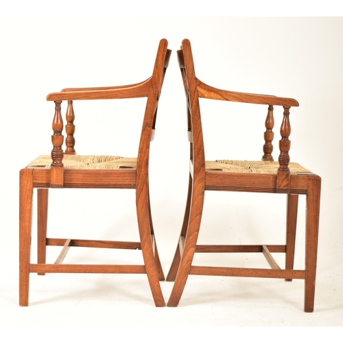 352 - A set of eight Regency early 19th century elm & rush seat dining chairs with carvers. Each chair hav... 