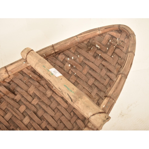 353 - A large African tribal hand woven wicker rattan canoe shaped cot / basket. The basket having a reinf... 