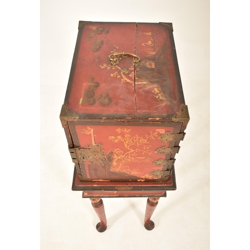 365 - A late 19th century Chinese red lacquered cabinet on stand. The cabinet top having a brass handle wi... 