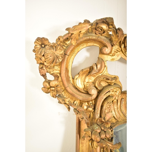 254 - A large Rococo inspired 19th century gilt wood & gesso overmantel mirror. The mirror having a intric... 