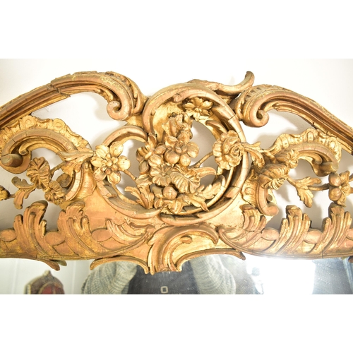 254 - A large Rococo inspired 19th century gilt wood & gesso overmantel mirror. The mirror having a intric... 