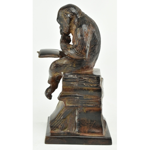 72 - A bronze figure depicting Darwin's reading monkey. The sculpture featuring a monkey reading a book i... 