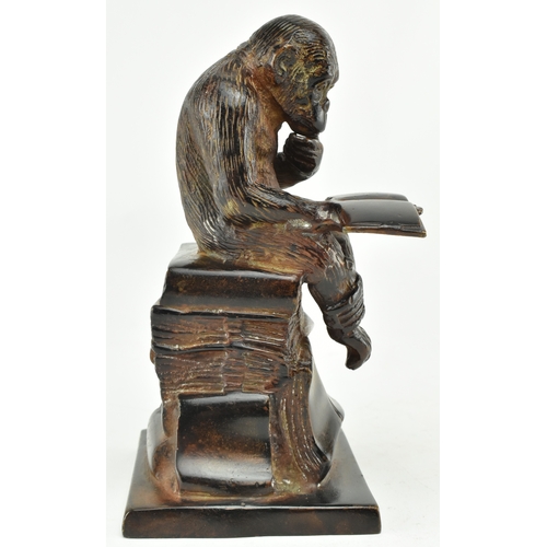 72 - A bronze figure depicting Darwin's reading monkey. The sculpture featuring a monkey reading a book i... 