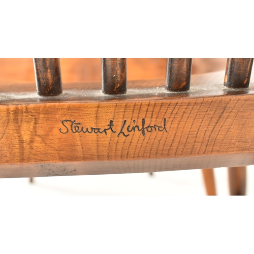 265 - Stewart Linford Furniture - A set of four plus two (matched) Windsor style yew & elm wood stick back... 