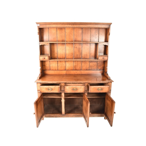 272 - A George III Revival Ipswich oak Welsh dresser. The dresser having a pediment atop over two panelled... 