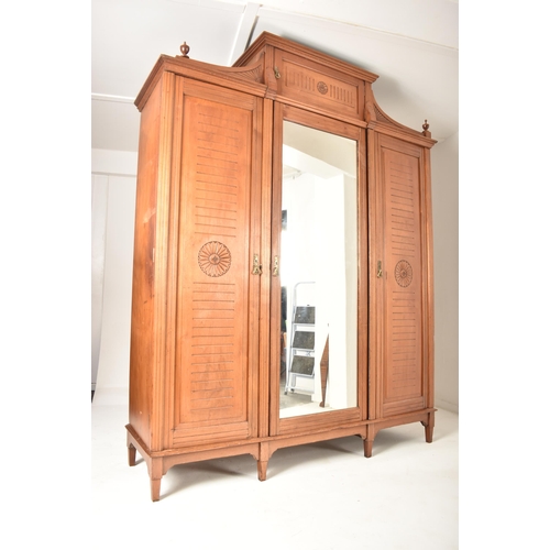 291 - A Victorian 19th century Arts & Crafts walnut triple wardrobe. The wardrobe having raised pediment a... 