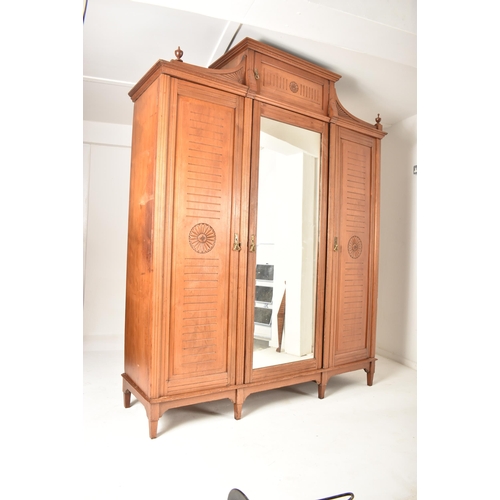 291 - A Victorian 19th century Arts & Crafts walnut triple wardrobe. The wardrobe having raised pediment a... 