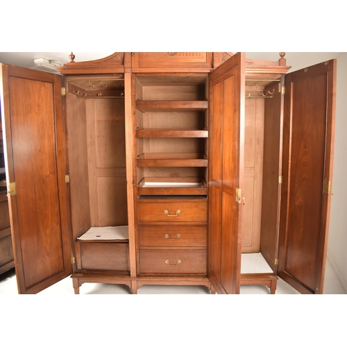 291 - A Victorian 19th century Arts & Crafts walnut triple wardrobe. The wardrobe having raised pediment a... 