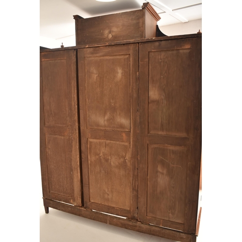 291 - A Victorian 19th century Arts & Crafts walnut triple wardrobe. The wardrobe having raised pediment a... 