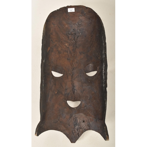 297 - A large East African Malawi carved wood wall mask. The mask depicting a harvesting carved scene atop... 