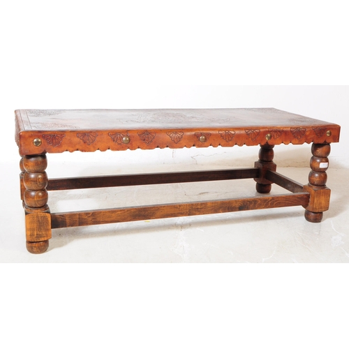 824 - An early 20th Century leather topped oak construction coffee table with turned bobbin legs with stre... 