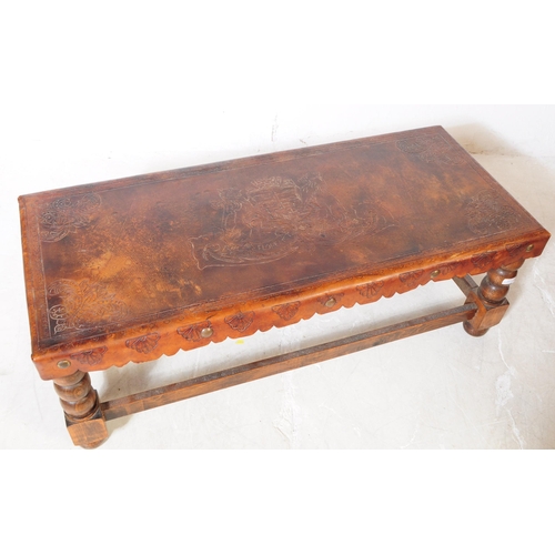 824 - An early 20th Century leather topped oak construction coffee table with turned bobbin legs with stre... 