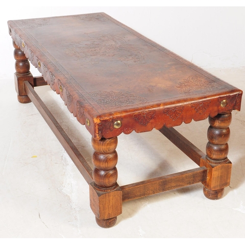 824 - An early 20th Century leather topped oak construction coffee table with turned bobbin legs with stre... 