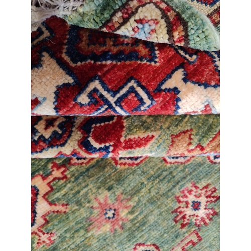 478 - A 20th century Kazak wool floor carpet rug from Kazakstan. Green and red ground with repeating patte... 