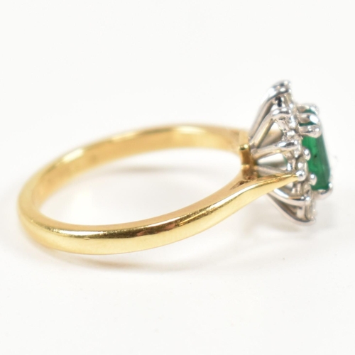 102 - A hallmarked 18ct gold, emerald and diamond cluster ring. The ring having a central emerald cut emer... 