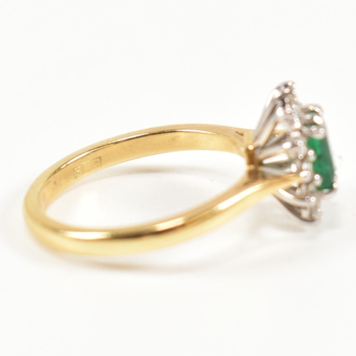 102 - A hallmarked 18ct gold, emerald and diamond cluster ring. The ring having a central emerald cut emer... 