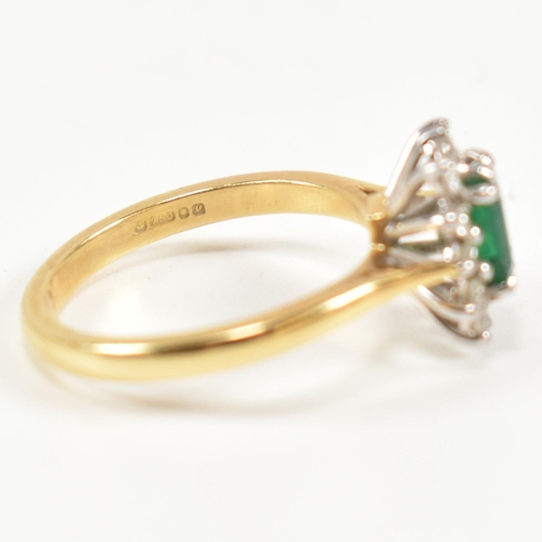 102 - A hallmarked 18ct gold, emerald and diamond cluster ring. The ring having a central emerald cut emer... 