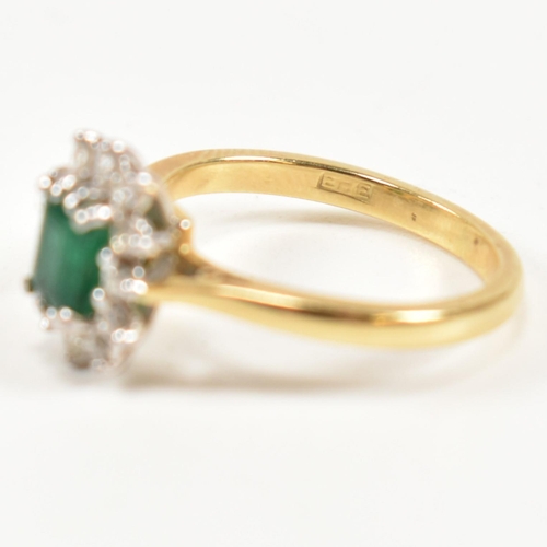 102 - A hallmarked 18ct gold, emerald and diamond cluster ring. The ring having a central emerald cut emer... 