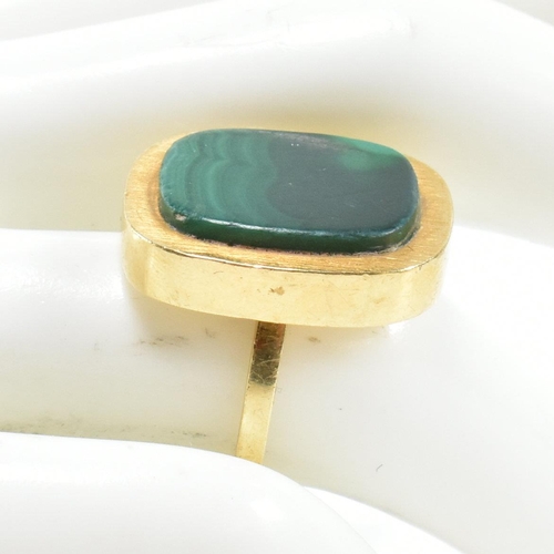 107 - A 1970s 18ct gold and malachite panel ring. The ring set with a malachite plaque. Stamped 18ct and S... 