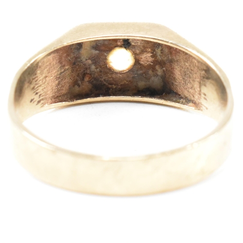 117 - A 9ct gold and gem set signet ring. The ring set with a single white spinel and having stylized shou... 