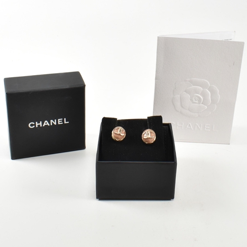 125 - A pair of Chanel gold plated and enamel earrings. The Chanel stud earrings having interlocking C mon... 