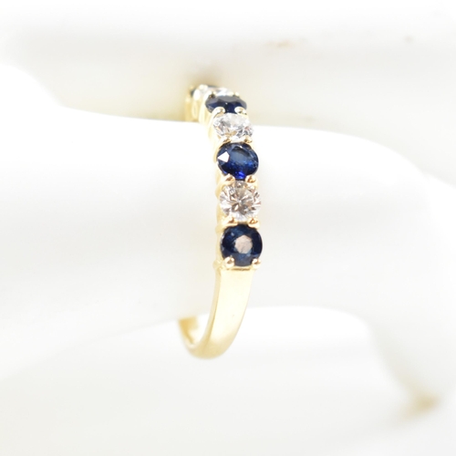 127 - A hallmarked 18ct gold, sapphire and diamond half hoop ring. The ring having four shared claw set ro... 