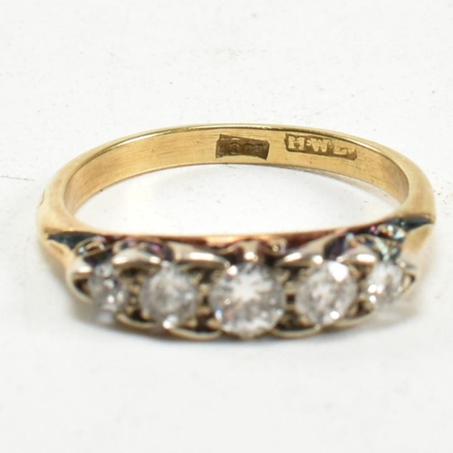 14 - An 18ct gold and diamond five stone ring. The ring set with five old cut diamonds to a scrolled gall... 