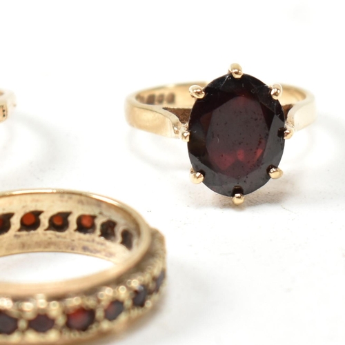 141 - Three 9ct yellow gold and garnet rings. The rings to include a hallmarked 9ct gold and oval cut garn... 