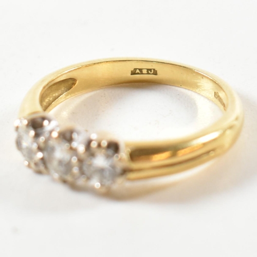 147 - A hallmarked 18ct gold and diamond trilogy ring. The ring three round cut diamonds set in a white go... 