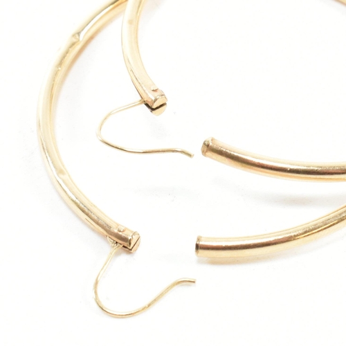 164 - A pair of gold hoop earrings. The gold hollow hoop earrings having endless fasteners. Unmarked, surf... 