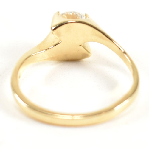 165 - A hallmarked 14ct gold and CZ crossover ring. The ring having a single round cut CZ set in a 14ct go... 