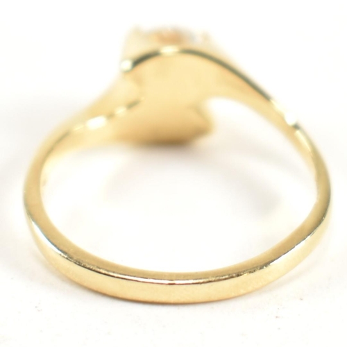 165 - A hallmarked 14ct gold and CZ crossover ring. The ring having a single round cut CZ set in a 14ct go... 