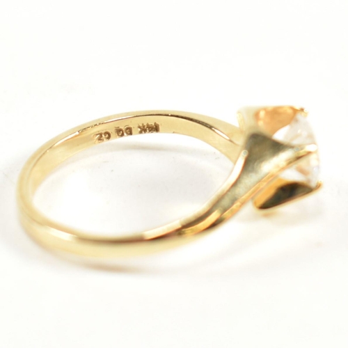 165 - A hallmarked 14ct gold and CZ crossover ring. The ring having a single round cut CZ set in a 14ct go... 