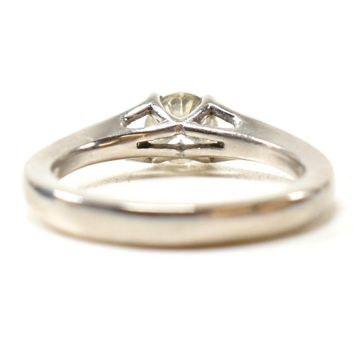 166 - A hallmarked platinum and diamond solitaire ring. The ring set with a single four claw set round cut... 