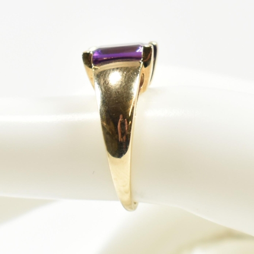 168 - A hallmarked 9ct gold and amethyst ring. The ring set with a central emerald cut amethyst in a domed... 