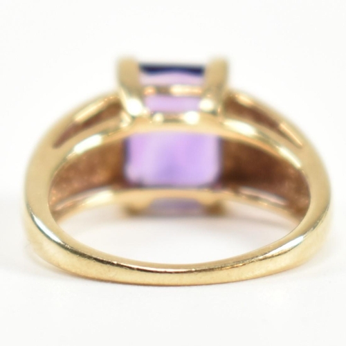 168 - A hallmarked 9ct gold and amethyst ring. The ring set with a central emerald cut amethyst in a domed... 