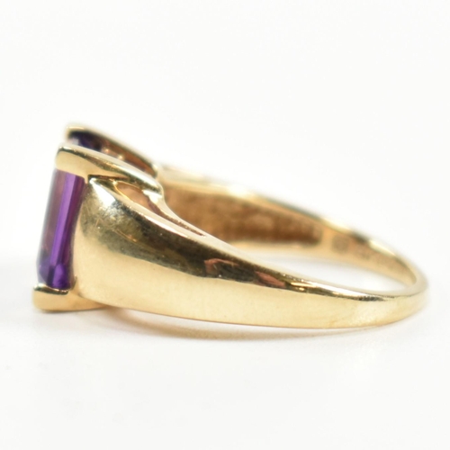 168 - A hallmarked 9ct gold and amethyst ring. The ring set with a central emerald cut amethyst in a domed... 