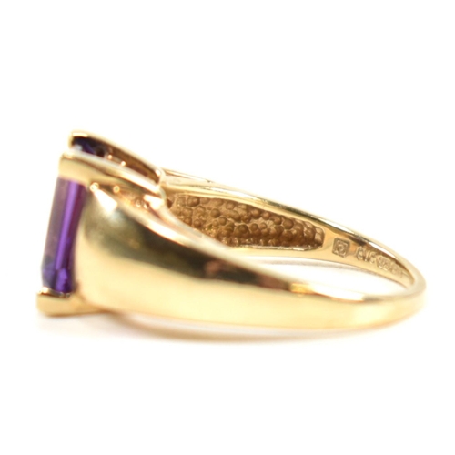 168 - A hallmarked 9ct gold and amethyst ring. The ring set with a central emerald cut amethyst in a domed... 