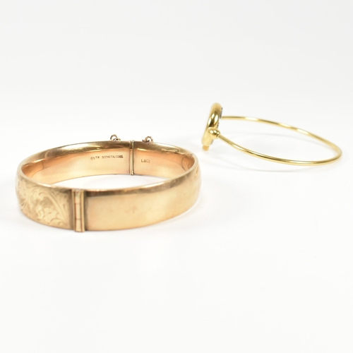 170 - A 9ct gold metal core hinged bangle and a gold tone metal bangle watch. The lot to include a 9ct gol... 