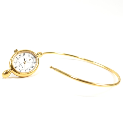 170 - A 9ct gold metal core hinged bangle and a gold tone metal bangle watch. The lot to include a 9ct gol... 